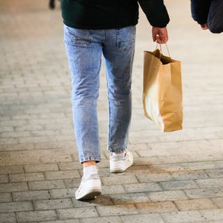 Zwei Jungs laufen mit Einkaufstaschen durch die Innenstadt. - In Mannheim kann man vielleicht ab Sommer mit Krypto im Supermarkt bezahlen. (Foto: dpa Bildfunk, picture alliance/dpa | Julian Stratenschulte)