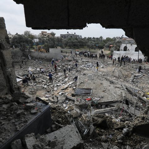 Menschen im Gazastreifen suchen nach einem Luftangriff nach ihren Habseligkeiten in den Trümmern ihrer Häuser.